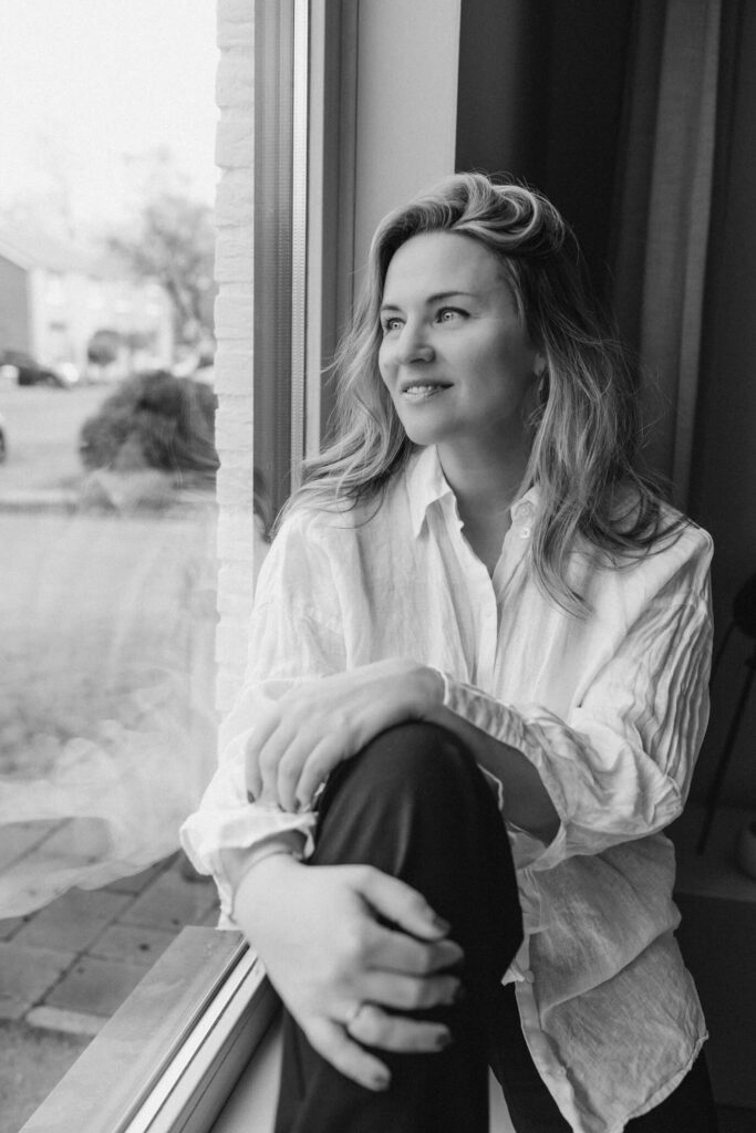 Sanne kijkt naar buiten door een raam